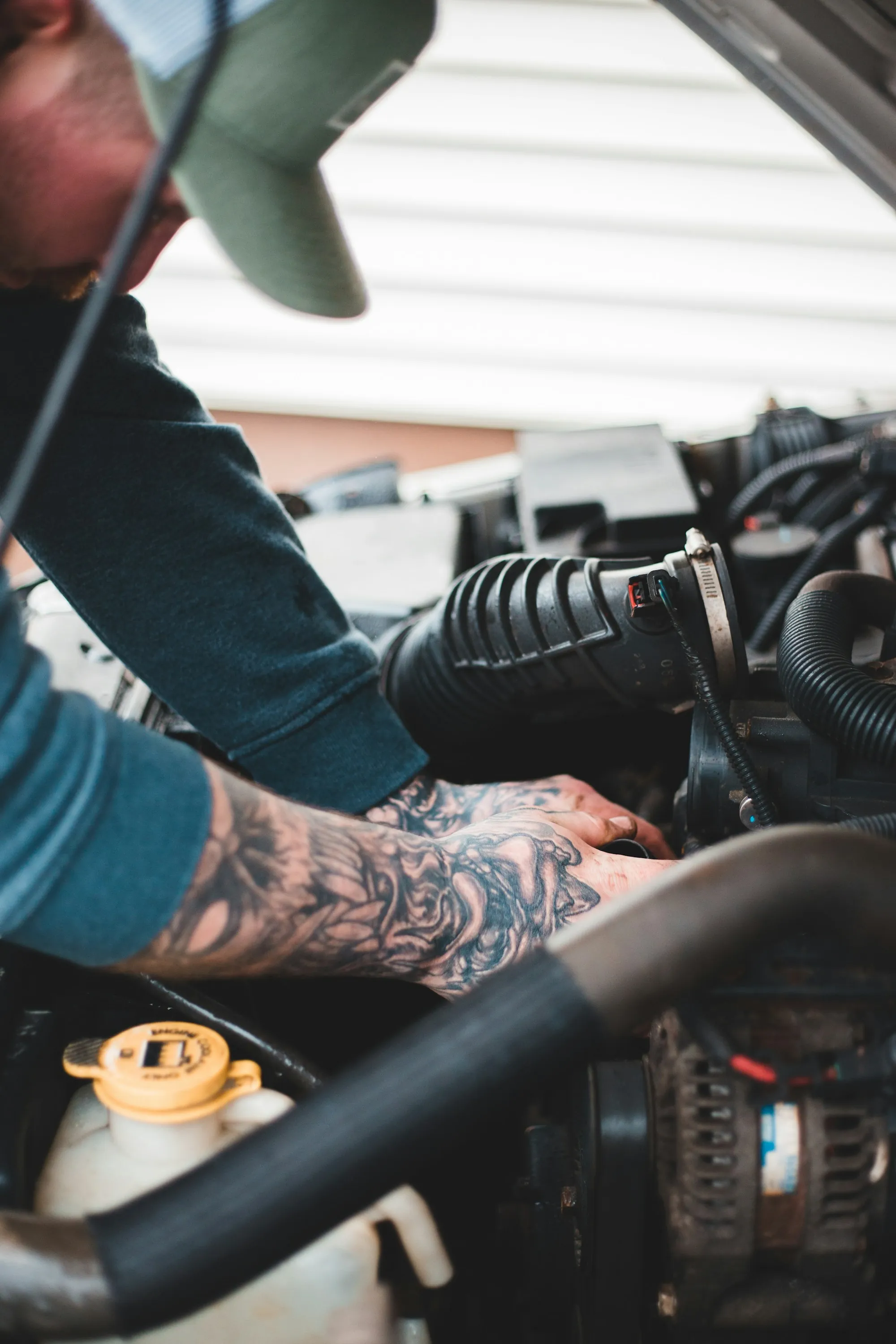 Close view of a hand tightening a bolt in an engine bay